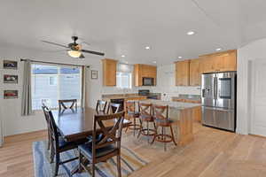 Dining room featuring light wood finished floors, ceiling fan, recessed lighting, and big windows