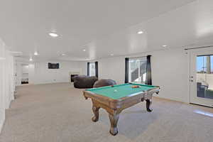Recreation room featuring healthy amount of natural light, recessed lighting, pool table, light carpet, and a textured ceiling