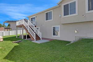Rear view of house with a deck, stairway, and stucco siding