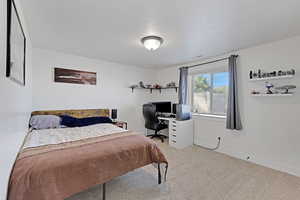 Bedroom with carpet, an office area,