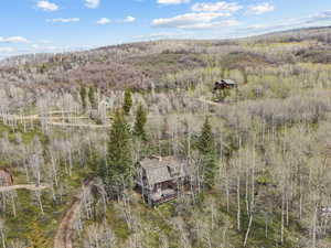 Aerial view of property and surrounding area featuring a forest