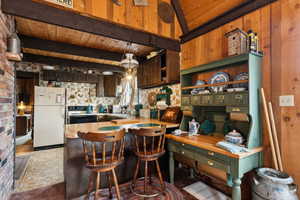 Kitchen with freestanding refrigerator, electric range, wooden ceiling, beamed ceiling, and open shelves
