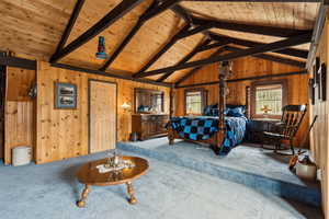 Carpeted bedroom with wooden ceiling and wooden walls