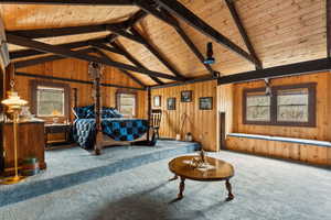 Carpeted bedroom featuring wooden ceiling and wood walls