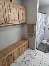 Bathroom with a shower with shower curtain and baseboards