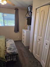 Bedroom featuring dark carpet and baseboards