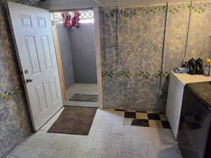 Bathroom featuring washing machine and dryer and tile patterned floors