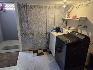 Laundry area with separate washer and dryer and tile patterned floors