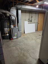 Unfinished below grade area featuring gas water heater and heating unit
