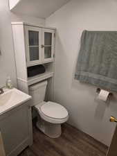Bathroom featuring wood finished floors, toilet, and vanity