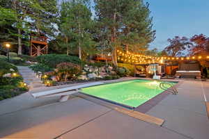 Outdoor pool with stairway, a diving board, and a patio area