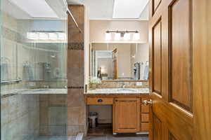 Full bath featuring a stall shower and vanity