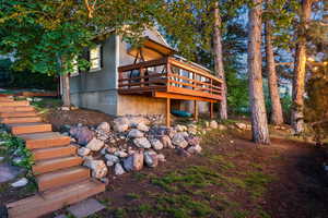 Back of property with stairs and a deck