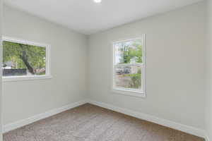 Empty room with carpet floors and baseboards