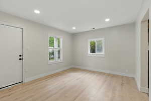 Foyer entrance with plenty of natural light, light wood-type flooring, recessed lighting, and baseboards
