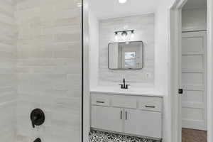 Full bath featuring vanity and washtub / shower combination