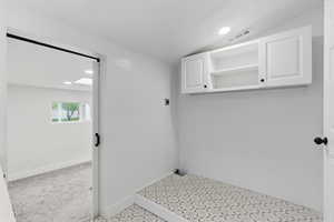 Clothes washing area with cabinet space, electric dryer hookup, baseboards, and recessed lighting