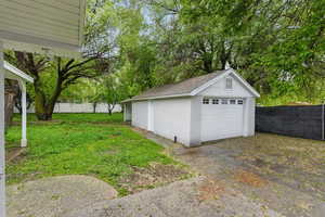 Detached garage featuring view of scattered trees