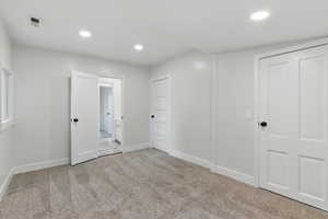 Unfurnished bedroom featuring carpet floors, baseboards, and recessed lighting
