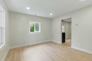 Spare room with healthy amount of natural light, light wood-style flooring, recessed lighting, and baseboards