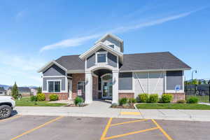 View of building exterior featuring fence and uncovered parking