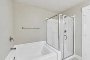 Full bathroom featuring a stall shower and a garden tub