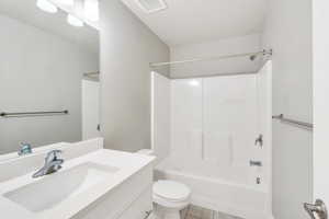 Bathroom featuring washtub / shower combination, toilet, and vanity