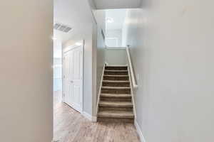 Stairs featuring baseboards, wood finished floors, and a textured ceiling