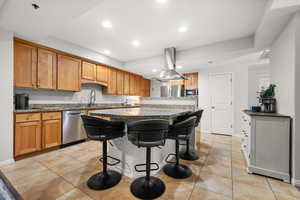 Kitchen with wood cabinetry, granite countertops, large conversation bar