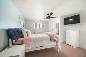 Bedroom featuring a textured ceiling, light colored carpet, a closet, a ceiling fan, and baseboards