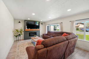 Living room featuring light wood finished floors, baseboards, healthy amount of natural light, and recessed lighting