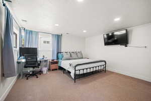 Bedroom with carpet flooring, recessed lighting, a textured ceiling, baseboards, and a desk