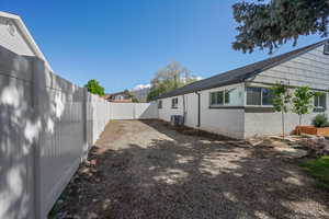 Fenced backyard featuring central air condition unit and a gate