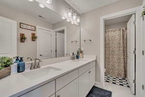 Bathroom with double vanity and a shower with shower curtain