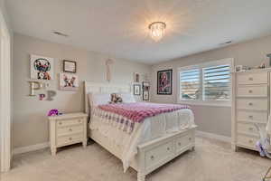 Bedroom with light colored carpet, baseboards, and a chandelier