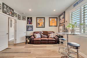 Den featuring recessed lighting and light wood-like laminate floors