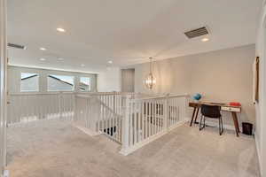 Hallway featuring carpet flooring, a chandelier, recessed lighting, an upstairs landing, and baseboards