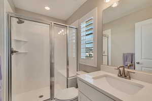 Full bathroom featuring a stall shower, toilet, and vanity