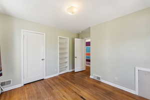 Unfurnished bedroom featuring wood finished floors and baseboards