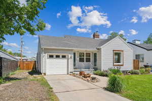 Single story home featuring concrete driveway, an attached garage, a chimney, and a shingled roof