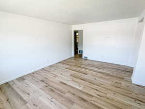 Empty room with light wood-style flooring and baseboards