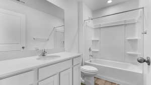 Full bath featuring wood finished floors, toilet, vanity, shower / bath combination, and recessed lighting