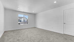 Carpeted spare room featuring baseboards, recessed lighting, and a textured ceiling