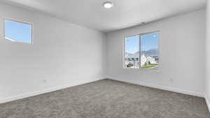 Carpeted empty room featuring plenty of natural light and baseboards