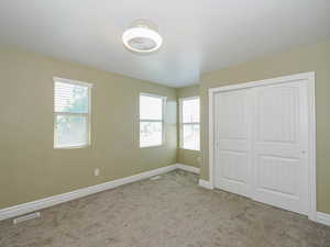 Unfurnished bedroom with carpet floors, baseboards, and a closet