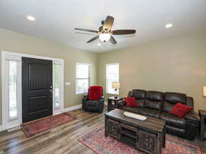 Living room with wood finished floors, baseboards, ceiling fan, and recessed lighting