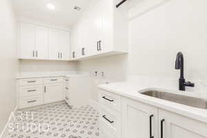 Laundry area featuring baseboards, cabinet space, hookup for a washing machine, and recessed lighting