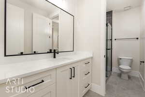 Full bathroom with vanity, toilet, a stall shower, and baseboards