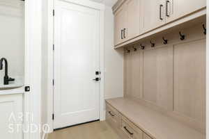 Mudroom featuring light wood-style floors and a sink
