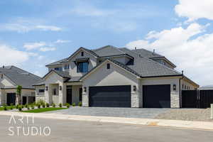 View of front of house featuring stone siding, stucco siding, a garage, decorative driveway, and a tile roof